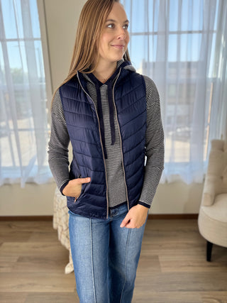 Photo of a woman in a navy vest.