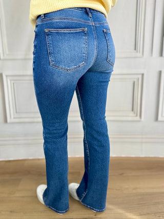Person wearing blue jeans with a neutral background
