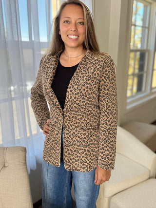 Woman wearing a leopard print blazer in a living room setting