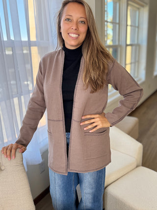 Photo of a woman in a taupe knit cardigan.