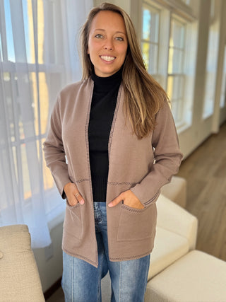 Photo of a woman in a taupe knit cardigan.