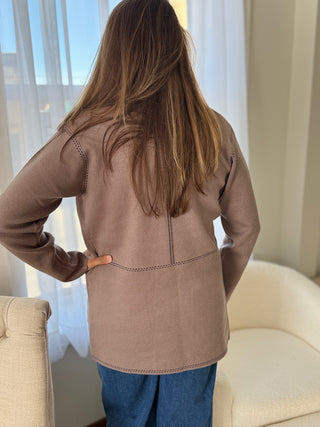 Photo of a woman in a taupe knit cardigan.