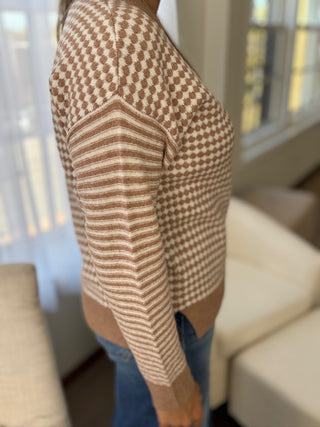 Person wearing a brown and beige patterned sweater in a home setting