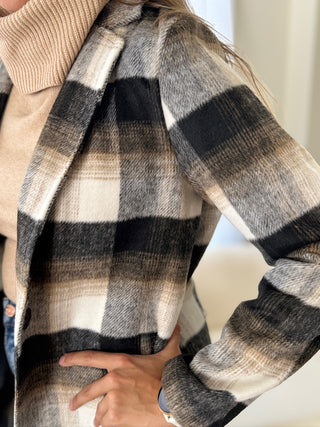 Person wearing a plaid scarf with a neutral background