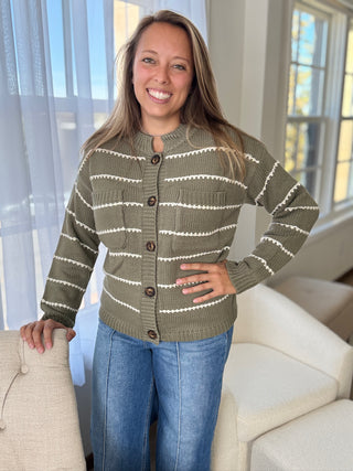 Woman wearing a green and white striped sweater in a living room setting