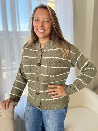 Woman wearing a green and white striped sweater indoors