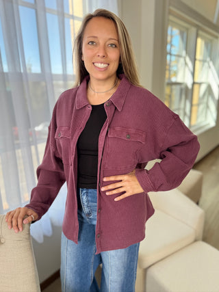 Woman wearing a purple corduroy jacket in a living room setting