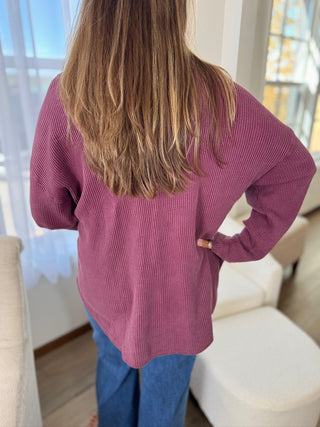 Person wearing a pink sweater in a room with light-colored furniture