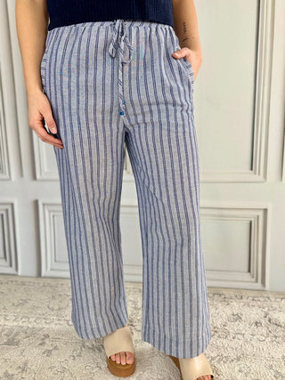Person wearing blue and white striped pants with a neutral background