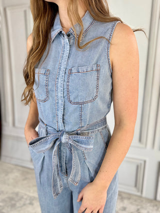 Light blue denim jumpsuit worn by a person with a neutral background