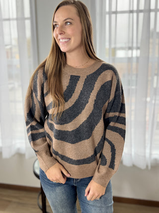 Woman wearing a brown and black patterned sweater indoors