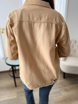 Person wearing a beige jacket in an indoor setting