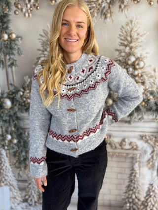 Woman wearing a patterned sweater in a decorated room