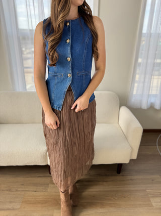 Photo of a woman in a fitted denim vest.