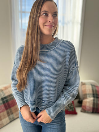 Woman wearing a blue striped sweater in a room with soft lighting
