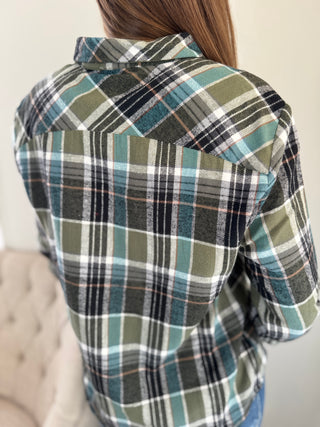 Plaid shirt worn by a person with a neutral background