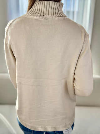 Beige sweater worn by a person with a neutral background