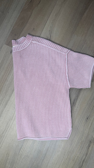 Pink knitted dress on a wooden floor
