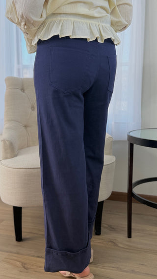 Navy pants worn by a person in a room with a chair and table.