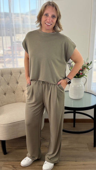 Woman wearing a beige outfit standing in a living room.