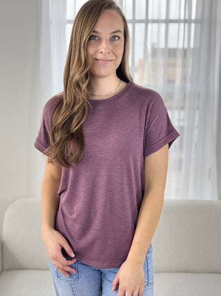 Woman wearing a purple t-shirt in a neutral setting