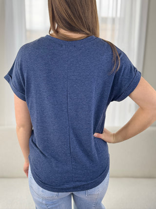 Person wearing a blue t-shirt in a neutral setting