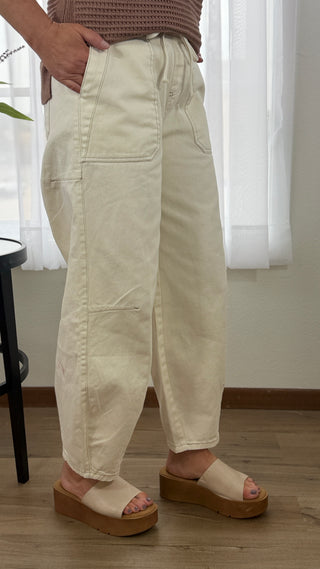 Person wearing beige pants and sandals indoors with a neutral background