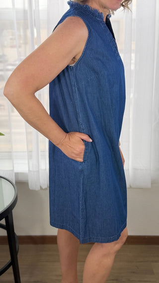 Woman wearing a blue denim dress with a blurred background