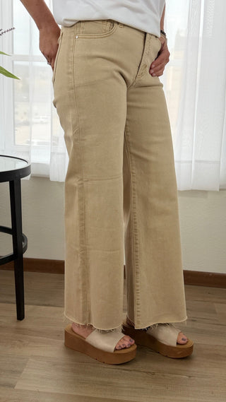 Person wearing beige wide-leg pants indoors with a neutral background