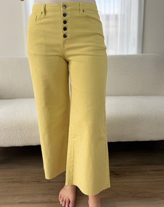 Yellow pants worn by a person in a room with a neutral background