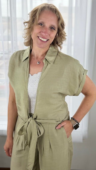 Woman wearing a green jumpsuit with a white background