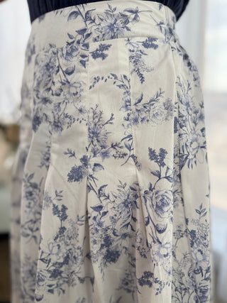 White skirt with blue floral pattern on a blurred background