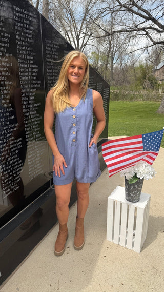 Woman is wearing a blue romper for Memorial Day.