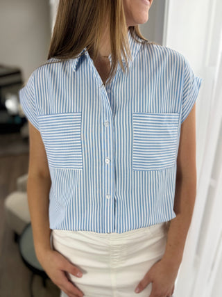 Woman wearing a blue and white striped sleeveless blouse with a blurred background