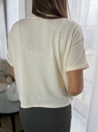 Person wearing a light-colored shirt with a blurred background