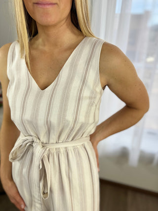 Woman wearing a white and gray striped dress with a blurred background