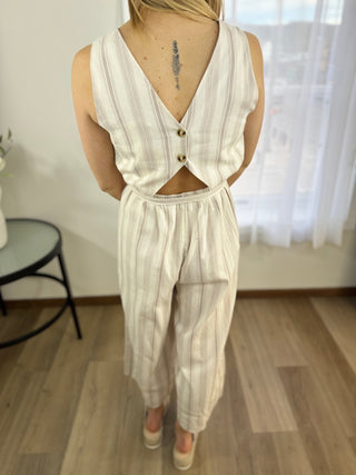 Person wearing a white striped sleeveless top and pants set indoors.