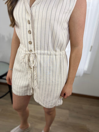 Person wearing a white pinstripe romper with a blurred background