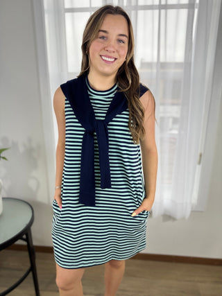 Woman wearing a striped dress with a navy scarf indoors