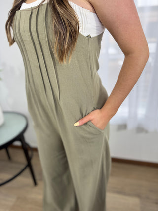 Person wearing a green jumpsuit with a blurred indoor background