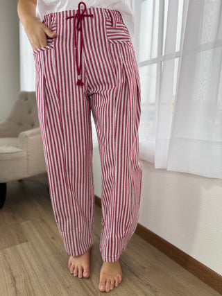 Red and white striped pajama pants worn by a person indoors.