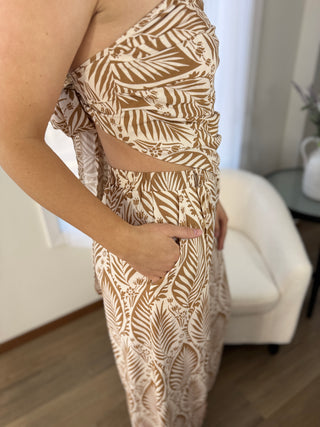 Person wearing a beige and brown patterned dress indoors.