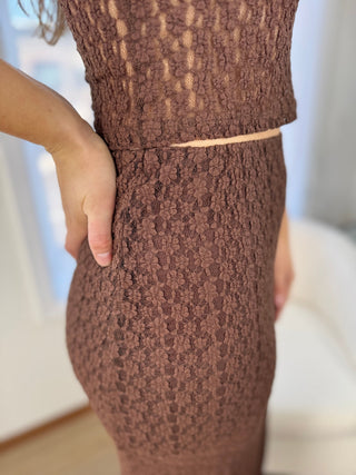 Brown textured dress worn by a person with a blurred background