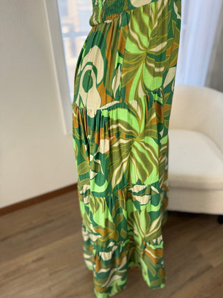 Green floral dress on a white chair with a neutral background