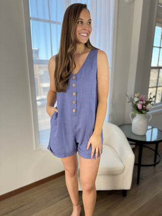 Woman wearing a blue romper in a living room setting