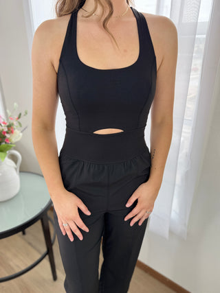 Person wearing a black athletic outfit with cut-out design in a bright room.