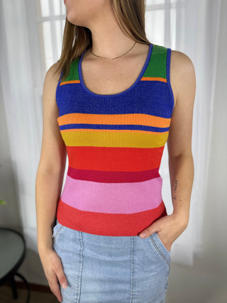 Person wearing a colorful striped tank top with a white background