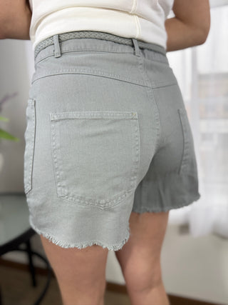 Light gray denim shorts worn by a person with a blurred background