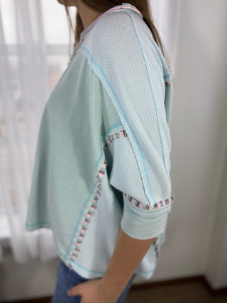 Light blue textured garment worn by a person with a blurred background