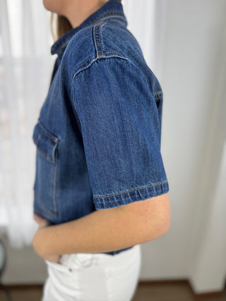 Person wearing a blue denim jacket with a neutral background
